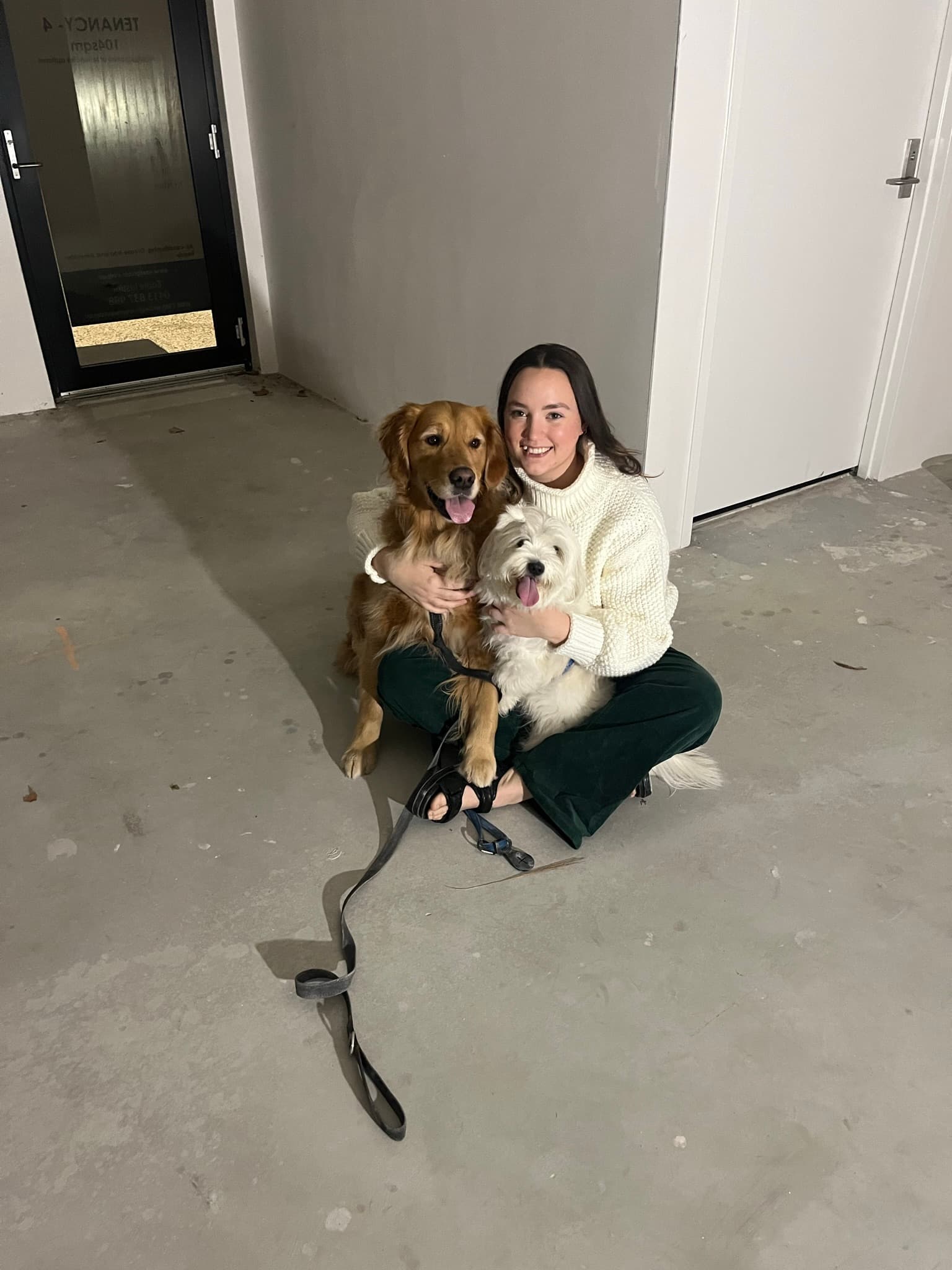Hayley and Jordan with their dogs in the empty salon space on the day they received the keys